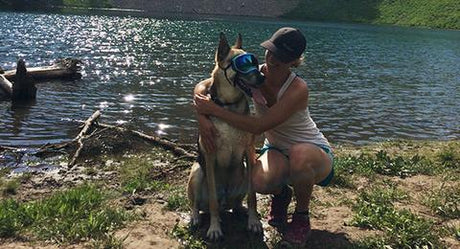 Woman hugging dog wearing Rex Specs Dog Goggles near Ski Lake